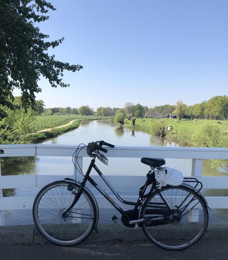 [bicycle on a bridge, water, meadows on the sides]