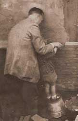 [old picture, me as a little boy, laying the ceremonial 
first brick of a building]