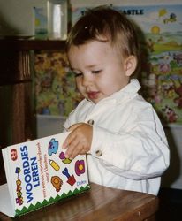 [A little boy holding a book 'Learning Words']